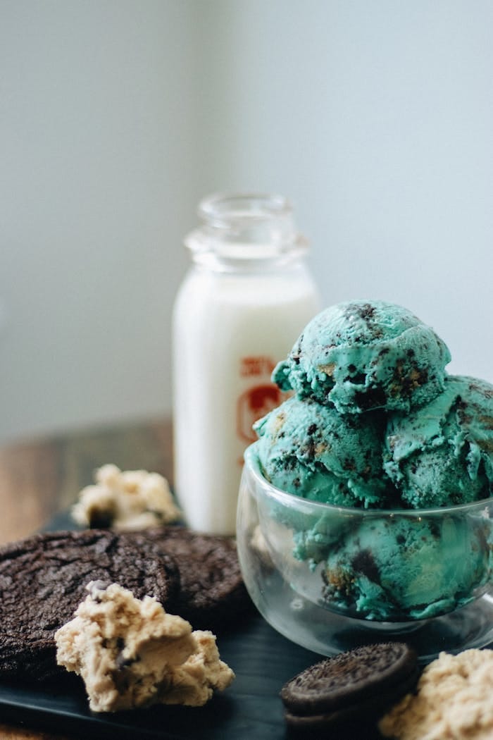 Indulge in artisan mint chocolate chip ice cream with cookies and milk.